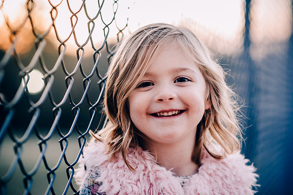 Portrait of a young girl in front of fence in Spring Hill , TN
