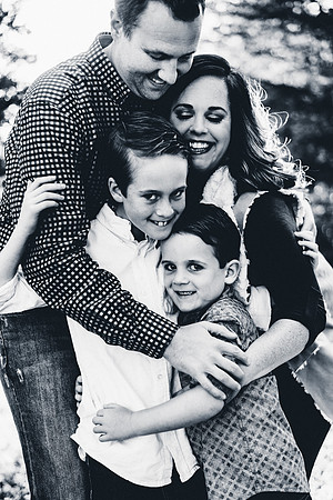 Black And White Photo of a Happy Family Of Four Hugging