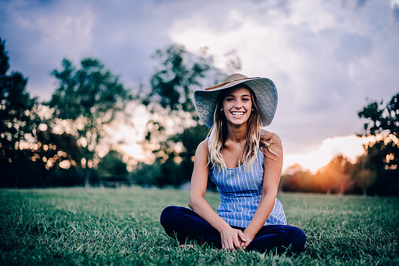 Senior teen girl smiling at camera wearing a hat at sunset at Henry Horton State Park